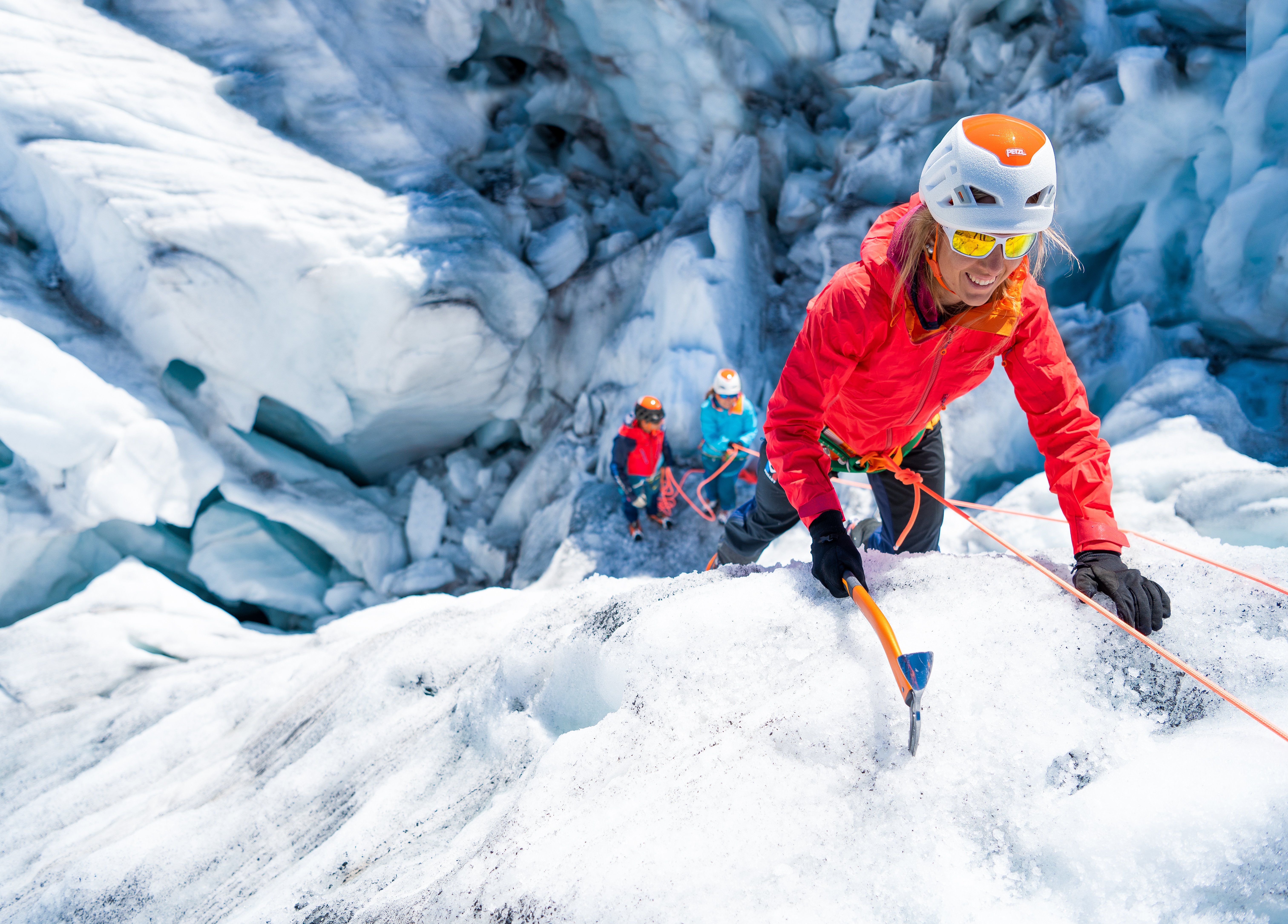 Bergsteiger klettert mit Pickel im Eis
